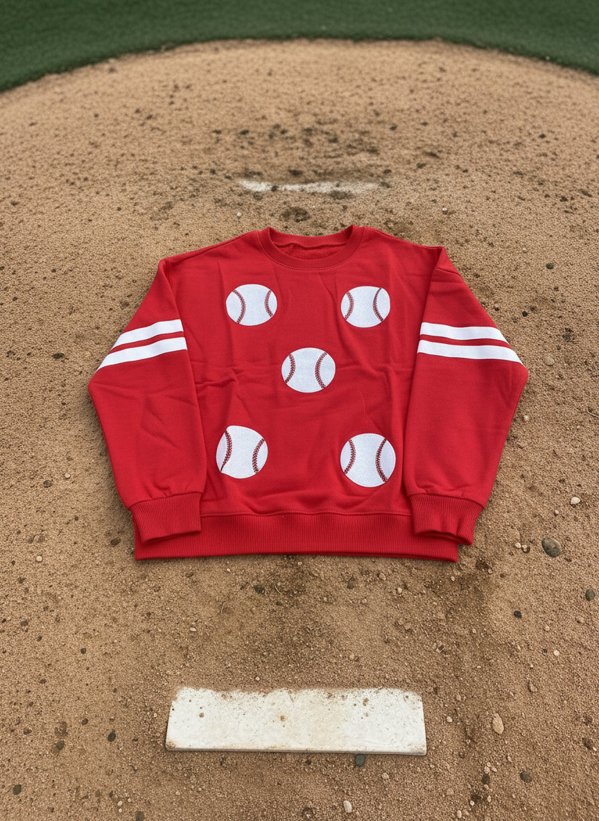 Red sweatshirt with white baseball graphics and stripes on a dark background